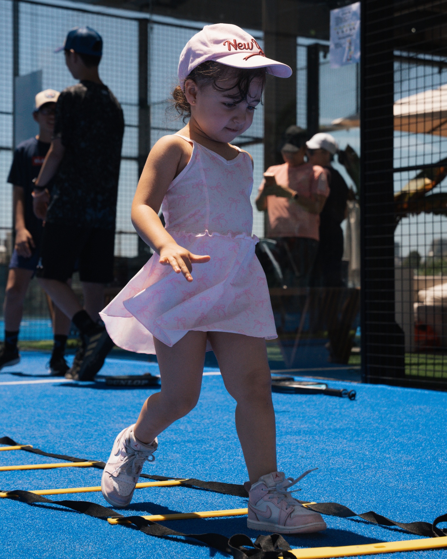 Little player working through agility ladders on court